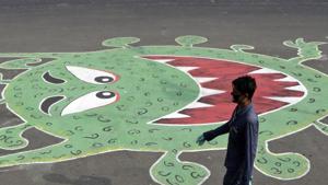 A man walks past a grafitti depicting the coronavirus, during a lockdown to control its spread in Mumbai, India.(AP) A man walks past a grafitti depicting the coronavirus, during a lockdown to control its spread in Mumbai, India.(AP)