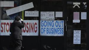 A woman looks at signs at a store in Niles, Illinois, US. Risk managers surveyed by the World Economic Forum expect a lengthy contraction in the global economy for the next 18 months.(AP File) A woman looks at signs at a store in Niles, Illinois, US. Risk managers surveyed by the World Economic Forum expect a lengthy contraction in the global economy for the next 18 months.(AP File)