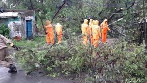 Odisha Disaster Rapid Action Force workers clearing roads in Balasore district after Cyclone Amphan uprooted trees as it made landfall on Wednesday afternoon.(HT PHOTO.) Odisha Disaster Rapid Action Force workers clearing roads in Balasore district after Cyclone Amphan uprooted trees as it made landfall on Wednesday afternoon.(HT PHOTO.)