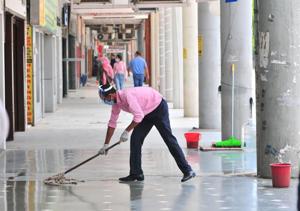 A man cleaning the corridor before opening a shop at the Plaza in Sector 17 in Chandigarh on Tuesday.(Ravi Kumar/HT) A man cleaning the corridor before opening a shop at the Plaza in Sector 17 in Chandigarh on Tuesday.(Ravi Kumar/HT)