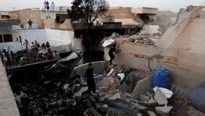 People stand on a roof of a house amidst debris of a passenger plane, crashed in a residential area near an airport in Karachi, Pakistan on May 22, 2020.(Reuters Photo) People stand on a roof of a house amidst debris of a passenger plane, crashed in a residential area near an airport in Karachi, Pakistan on May 22, 2020.(Reuters Photo)