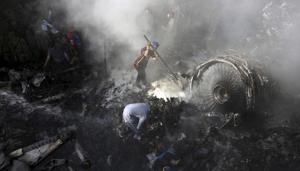 Volunteers look for survivors of a plane that crashed in a residential area of Karachi, Pakistan, May 22, 2020.(AP photo) Volunteers look for survivors of a plane that crashed in a residential area of Karachi, Pakistan, May 22, 2020.(AP photo)