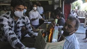 A man buys bottles of liquor outside a wine store during a nationwide lockdown to curb the spread of new coronavirus in Jammu.(AP File Photo) A man buys bottles of liquor outside a wine store during a nationwide lockdown to curb the spread of new coronavirus in Jammu.(AP File Photo)