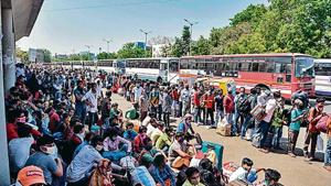Migrant workers and families wait for transportation at the Ahmedabad railway station on Saturday. Migrant workers and families wait for transportation at the Ahmedabad railway station on Saturday.