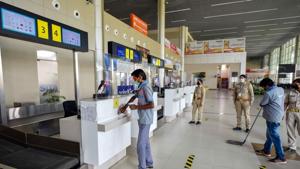 Security personnel stand guard as airport staff sanitse Prayagraj airport during the fourth phase of Covid-19 nationwide lockdown, in Prayagraj on Sunday.(PTI Photo)