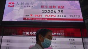A man wearing a face mask walks past a bank electronic board showing the Hong Kong share index at Hong Kong Stock Exchange on Thursday.(AP File Photo) A man wearing a face mask walks past a bank electronic board showing the Hong Kong share index at Hong Kong Stock Exchange on Thursday.(AP File Photo)