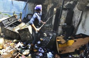 Firemen at a shed in the backyard of a Sector 37 house. Cupboards and other items stored there were completely damaged in the fire.(Keshav Singh/HT) Firemen at a shed in the backyard of a Sector 37 house. Cupboards and other items stored there were completely damaged in the fire.(Keshav Singh/HT)