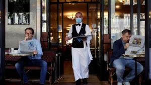 A waiter wearing a face mask serves at Cafe de Flore, as restaurants and cafes reopen following the coronavirus disease (COVID-19) outbreak, in Paris, France, June 2, 2020. REUTERS/Christian Hartmann(REUTERS) A waiter wearing a face mask serves at Cafe de Flore, as restaurants and cafes reopen following the coronavirus disease (COVID-19) outbreak, in Paris, France, June 2, 2020. REUTERS/Christian Hartmann(REUTERS)