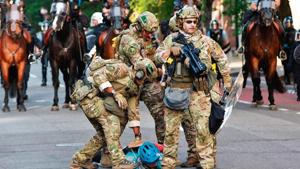 Military police officers restrain a protester near the White House in Washington, DC. Military police officers restrain a protester near the White House in Washington, DC.