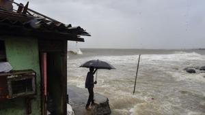 A man stands near a house built on the edge of the Arabian Sea at Bandra, ahead of Cyclone Nisarga’s expected landfall, in Mumbai, on Wednesday.(PTI Photo) A man stands near a house built on the edge of the Arabian Sea at Bandra, ahead of Cyclone Nisarga’s expected landfall, in Mumbai, on Wednesday.(PTI Photo)