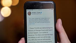 A tweet by U.S. President Donald Trump with a rule-violation notice that includes the phrase "when the looting starts, the shooting starts" is displayed on a smartphone in an arranged photograph taken in Arlington, Virginia, US.(Bloomberg) A tweet by U.S. President Donald Trump with a rule-violation notice that includes the phrase "when the looting starts, the shooting starts" is displayed on a smartphone in an arranged photograph taken in Arlington, Virginia, US.(Bloomberg)
