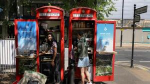 Loreinis Mejia Hernandez from Colombia reacts at a converted telephone box she runs as a take-away coffee shop with her husband.(Reuters) Loreinis Mejia Hernandez from Colombia reacts at a converted telephone box she runs as a take-away coffee shop with her husband.(Reuters)