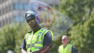 A flag, bearing a leftist symbol associated with Antifa, is reflected behind a Boston Police officer during the Straight Pride Parade rally in Boston, Massachusetts, US.(REUTERS) A flag, bearing a leftist symbol associated with Antifa, is reflected behind a Boston Police officer during the Straight Pride Parade rally in Boston, Massachusetts, US.(REUTERS)