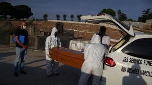Healthcare workers take the coffin of a 76-year-old who died due to Covid-19 in Rio de Janeiro, Brazil , on June 6.(Reuters Photo) Healthcare workers take the coffin of a 76-year-old who died due to Covid-19 in Rio de Janeiro, Brazil , on June 6.(Reuters Photo)