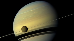 Saturn’s moon Titan is seen here as it orbits the planet. Below Titan are the shadows cast by Saturn’s rings. This natural color view was created by combining six images captured by NASA’s Cassini spacecraft on May 6, 2012.(Photo Credit: NASA/ JPL-Caltech/Spac Science Institute) Saturn’s moon Titan is seen here as it orbits the planet. Below Titan are the shadows cast by Saturn’s rings. This natural color view was created by combining six images captured by NASA’s Cassini spacecraft on May 6, 2012.(Photo Credit: NASA/ JPL-Caltech/Spac Science Institute)