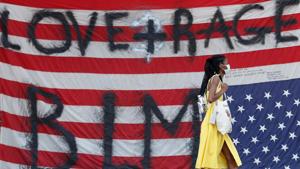 A woman walks in front of an upside down U.S. flag affixed to the Seattle Police Department East Precinct building at the self-proclaimed Capitol Hill Autonomous Zone (CHAZ) during a protest against racial inequality and call for defunding of Seattle police, in Seattle, Washington.(REUTERS) A woman walks in front of an upside down U.S. flag affixed to the Seattle Police Department East Precinct building at the self-proclaimed Capitol Hill Autonomous Zone (CHAZ) during a protest against racial inequality and call for defunding of Seattle police, in Seattle, Washington.(REUTERS)