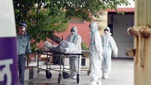 A medical team wheels out the body of a person who died of Covid-19 during a handover to family members outside the mortuary at GTB Hospital in north east Delhi on Saturday.(Sonu Mehta/HT PHOTO) A medical team wheels out the body of a person who died of Covid-19 during a handover to family members outside the mortuary at GTB Hospital in north east Delhi on Saturday.(Sonu Mehta/HT PHOTO)