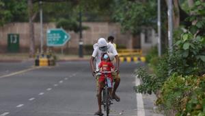 A cyclist travelling with a child at Connaught Place in New Delhi.(Sonu Mehta/HT PHOTO) A cyclist travelling with a child at Connaught Place in New Delhi.(Sonu Mehta/HT PHOTO)
