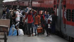 Migrant laborers walk with their belongings after arriving from Maharashtra state, in Prayagraj.(AP) Migrant laborers walk with their belongings after arriving from Maharashtra state, in Prayagraj.(AP)