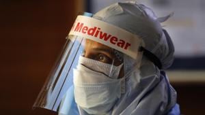 A health worker in protective suit listens to people standing in a queue for COVID 19 test at Sir Ganga Ram hospital in New Delhi.(AP) A health worker in protective suit listens to people standing in a queue for COVID 19 test at Sir Ganga Ram hospital in New Delhi.(AP)
