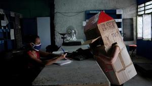 Retired Cuban nurse Feridia Rojas, 82, wears cardboard shaped into a house.(REUTERS) Retired Cuban nurse Feridia Rojas, 82, wears cardboard shaped into a house.(REUTERS)