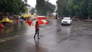 A child crossing the road with an umbrella as it rains, in Patna, Bihar on Thursday.(AP Dube/HT Photo)