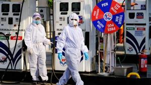 Employees wear personal protective equipment (PPE) at a Hindustan Petroleum Corp. gas station during a lockdown imposed due to the coronavirus in New Delhi.(Bloomberg Photo)
