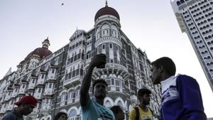 A visitor poses for a photograph outside the Taj Mahal Palace hotel in Mumbai.(Bloomberg File Photo) A visitor poses for a photograph outside the Taj Mahal Palace hotel in Mumbai.(Bloomberg File Photo)