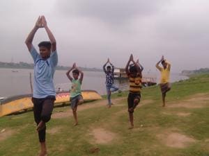 In absence of training, young rowers doing yoga and excercise at the banks of river Yamuna in Prayagraj.(HT) In absence of training, young rowers doing yoga and excercise at the banks of river Yamuna in Prayagraj.(HT)