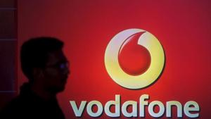 A man casts a silhouette onto an electronic screen displaying a Vodafone logo, in Mumbai.(REUTERS) A man casts a silhouette onto an electronic screen displaying a Vodafone logo, in Mumbai.(REUTERS)