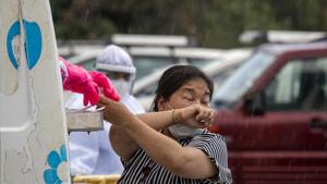A woman sneezes as a doctor prepares to take a nasal swab to be tested for the coronavirus in Dharmsala.(AP File Photo) A woman sneezes as a doctor prepares to take a nasal swab to be tested for the coronavirus in Dharmsala.(AP File Photo)