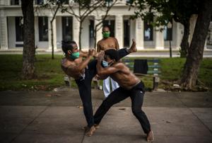 Wearing protective face masks as a precaution against the spread of the new coronavirus, Victor Rafael Torres, left, and Eiver Carbonell train in capoeira in a park while his teacher Misael watches them, after an easing of COVID-19 related lockdown restrictionsin Havana, Cuba, Friday, July 3, 2020.(AP) Wearing protective face masks as a precaution against the spread of the new coronavirus, Victor Rafael Torres, left, and Eiver Carbonell train in capoeira in a park while his teacher Misael watches them, after an easing of COVID-19 related lockdown restrictionsin Havana, Cuba, Friday, July 3, 2020.(AP)