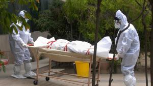 Medics wearing PPE kits carry the body of a person who died of COVID-19 at a district hospital, in Noida.(PTI) Medics wearing PPE kits carry the body of a person who died of COVID-19 at a district hospital, in Noida.(PTI)