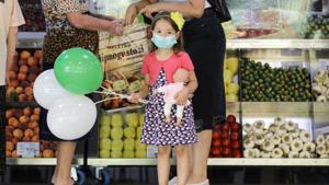 FILE- A child wearing a face mask clutches a doll at a food market in Bucharest, Romania, Wednesday, July 1, 2020.(AP)