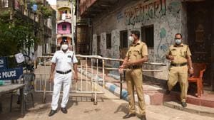 Police personnel stand guard outside a sealed residential complex following a hike in Covid-19 cases in Kolkata. Authorities have announced total lockdown in containment zones across the state.(PTI PHOTO.)