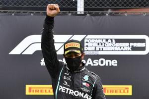 Mercedes' Lewis Hamilton wears a protective face mask as he celebrates winning the race on the podium with the trophy, following the resumption of F1 after the outbreak of the coronavirus disease (COVID-19) Joe Klamar/Pool via REUTERS(REUTERS) Mercedes' Lewis Hamilton wears a protective face mask as he celebrates winning the race on the podium with the trophy, following the resumption of F1 after the outbreak of the coronavirus disease (COVID-19) Joe Klamar/Pool via REUTERS(REUTERS)