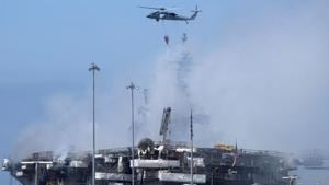 The USS Bonhomme Richard, an amphibious assault ship whose size ranks second in the US Navy fleet to that of an aircraft carrier, remained largely shrouded in thick, acrid smoke on Monday.(REUTERS) The USS Bonhomme Richard, an amphibious assault ship whose size ranks second in the US Navy fleet to that of an aircraft carrier, remained largely shrouded in thick, acrid smoke on Monday.(REUTERS)