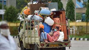 Migrants with their belongings travel in a tempo as they leave the city after authorities announced one week lockdown due to surge in Covid-19 cases in Bengaluru on Monday.(PTI Photo) Migrants with their belongings travel in a tempo as they leave the city after authorities announced one week lockdown due to surge in Covid-19 cases in Bengaluru on Monday.(PTI Photo)