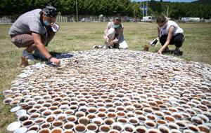 Artist Aida Sehovic (centre) helps install her collection of some 8,000 traditional ceramic cups filled with Bosnian coffee at the Potocari-Srebrenica Memorial Centre for victims of the 1995 massacre of Muslim men and boys by Serb forces, in eastern Bosnia, July 10, 2020.(REUTERS) Artist Aida Sehovic (centre) helps install her collection of some 8,000 traditional ceramic cups filled with Bosnian coffee at the Potocari-Srebrenica Memorial Centre for victims of the 1995 massacre of Muslim men and boys by Serb forces, in eastern Bosnia, July 10, 2020.(REUTERS)