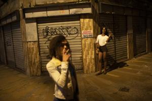 Transgender sex worker Alice Larubia smokes a cigarette as she waits for customers in Niteroi, Brazil, Saturday, June 27, 2020, amid the new coronavirus pandemic. After a month quarantining at home with some financial support from family, Larubia resumed work in Niteroi, a city across the bay from Rio. “Necessity spoke louder (than the pandemic) and I had to come back to the street,” Larubia said while waiting for clients with a small group of colleagues.(AP) Transgender sex worker Alice Larubia smokes a cigarette as she waits for customers in Niteroi, Brazil, Saturday, June 27, 2020, amid the new coronavirus pandemic. After a month quarantining at home with some financial support from family, Larubia resumed work in Niteroi, a city across the bay from Rio. “Necessity spoke louder (than the pandemic) and I had to come back to the street,” Larubia said while waiting for clients with a small group of colleagues.(AP)