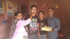 Topper, Kishore Kumar, celebrating his score with his parents in Kurali on Wednesday. His parents run a tea stall.(HT Photo) Topper, Kishore Kumar, celebrating his score with his parents in Kurali on Wednesday. His parents run a tea stall.(HT Photo)