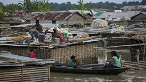 A flood affected family takes shelter on the roof of their partially submerged house along river Brahmaputra in Morigaon district, Assam.(AP) A flood affected family takes shelter on the roof of their partially submerged house along river Brahmaputra in Morigaon district, Assam.(AP)
