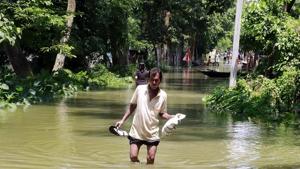 A villager wades through the waterlogged road at a flood-affected Lalmati Village in Assam’sTezpur(ANI)