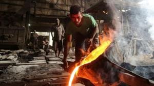 A worker pours molten iron from a ladle to make automobile spare parts inside an iron casting factory in Ahmedabad, India.(REUTERS) A worker pours molten iron from a ladle to make automobile spare parts inside an iron casting factory in Ahmedabad, India.(REUTERS)