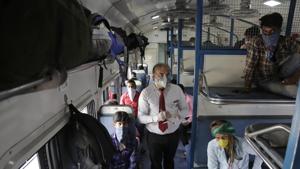 A ticket collector checks the tickets of migrant workers siting inside a special train to return to Agra in Uttar Pradesh state.(AP) A ticket collector checks the tickets of migrant workers siting inside a special train to return to Agra in Uttar Pradesh state.(AP)
