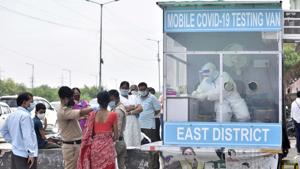 People outside a mobile Covid-19 rapid antigen testing kiosk in New Delhi’s New Ashok Nagar area on Tuesday.(Mohd Zakir/HT PHOTO)