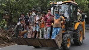 Labourers ride in the bucket of a payloader to their worksite after some restrictions were lifted during an extended nationwide lockdown to slow the spread of the coronavirus disease (Covid-19), in Kolkata.(REUTERS) Labourers ride in the bucket of a payloader to their worksite after some restrictions were lifted during an extended nationwide lockdown to slow the spread of the coronavirus disease (Covid-19), in Kolkata.(REUTERS)