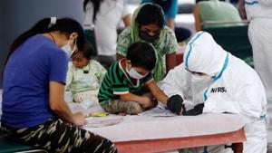 A medical worker helps a boy to draw inside a care centre for the coronavirus disease (Covid-19) patients at an indoor sports complex in New Delhi,on July 20.(Reuters Photo) A medical worker helps a boy to draw inside a care centre for the coronavirus disease (Covid-19) patients at an indoor sports complex in New Delhi,on July 20.(Reuters Photo)