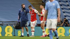 Arsenal's Shkodran Mustafi is assisted from the field during the FA Cup semifinal soccer match between Arsenal and Manchester City at Wembley in London.(AP) Arsenal's Shkodran Mustafi is assisted from the field during the FA Cup semifinal soccer match between Arsenal and Manchester City at Wembley in London.(AP)