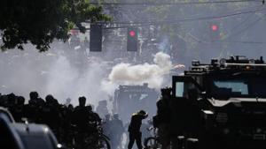 Police in riot gear faced off against the demonstrators, some of whom held up umbrellas against falling pellets of pepper spray.(AP Photo) Police in riot gear faced off against the demonstrators, some of whom held up umbrellas against falling pellets of pepper spray.(AP Photo)
